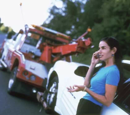 pomoc drogowa i kobieta rozmawiająca przez telefon